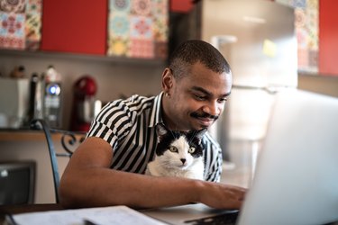 Man working at home with his domestic cat