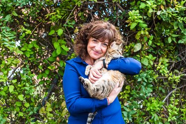 Portrait Of Smiling Woman Holding Cat Outside