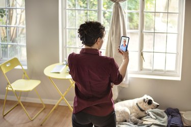 Young woman consulting her doctor using a smart phone app