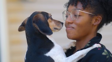 small dog being held by young woman