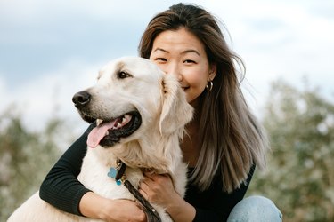 Portrait of Young Woman Hugging Her Dog