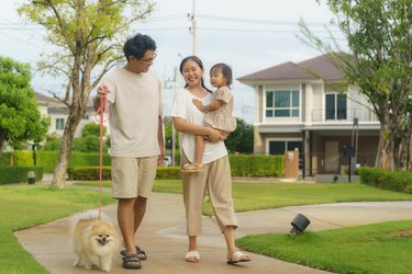 Asian family with dog walking outside
