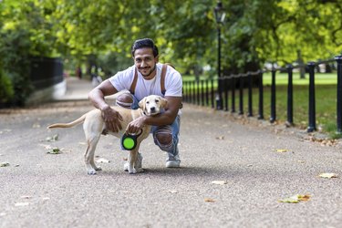 Smiling man with a puppy in a park