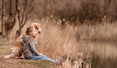 Preteen girl with golden retriever dog