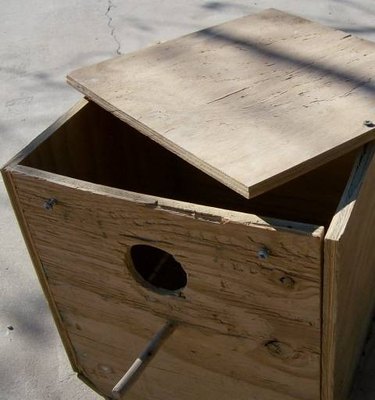 A wooden bird house with disassembled roof