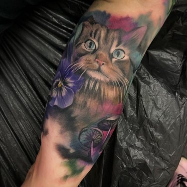 A realistic tattoo of cat looks like watercolor painting.