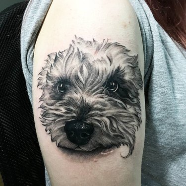 A realistic closeup tattoo of a dog's face.