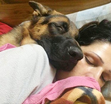 dog snuggles with woman