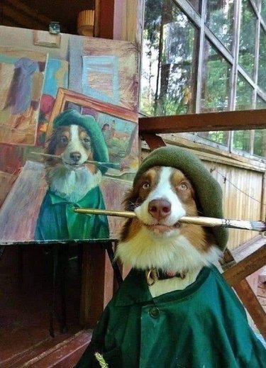 dog poses in front of painting