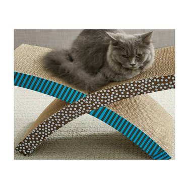 A grey cat resting on a Petstages Scratch 'n Rest Cat Scratcher