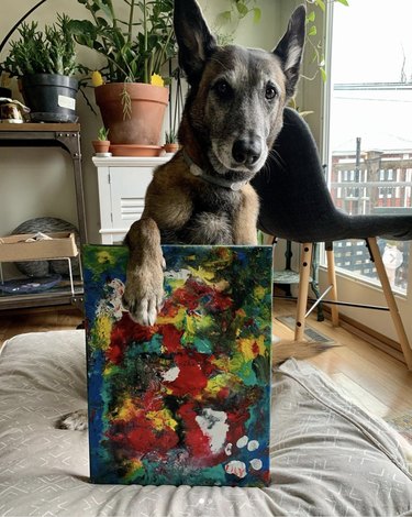 dog with his paw on his painting.