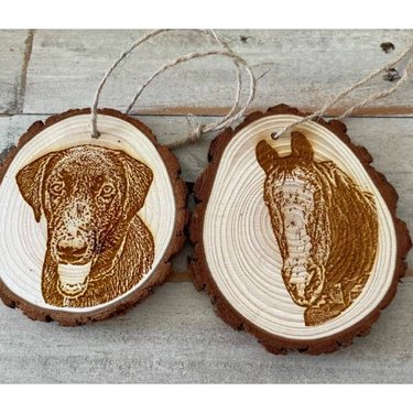 Two wood clice ornaments with a dog and horse engraved on each