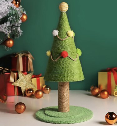 Christmas-tree shaped cat scratcher with pompom ornaments.
