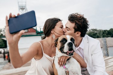 engaged couple takes selfie with dog