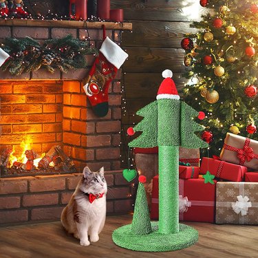 A cat sitting next to a BOLUO Cat Scratching Post Tall Ceder Christmas Cat Tree