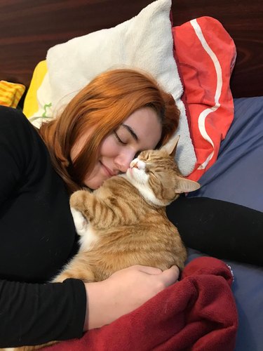 woman and cat snuggling and sharing a brain cell