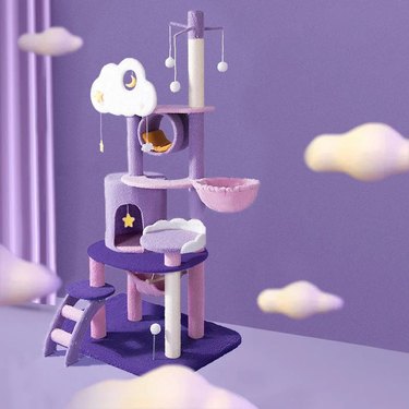 Purple cat tree featuring cloud, star, and moon motifs with multiple hammocks, resting spots, hideaways, and balls for batting.