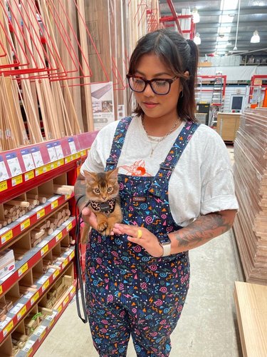 A woman takes her kitten with her to the hardware store.