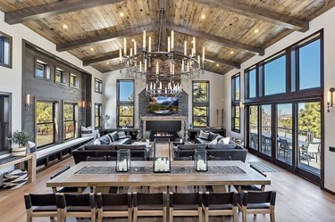 Spacious living room with vaulted ceilings, Restoration Hardware leather sectionals, a fireplace, and a 12-person dining table.