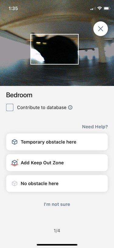 Roomba reports cat as an obstacle while vaccuming in a bedroom.