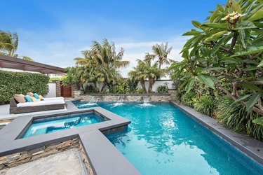 Outdoor pool and spa with lush greenery in Newport Beach, CA.