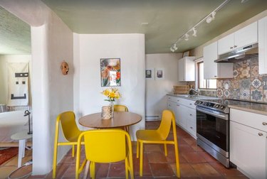 The kitchen in Casa Estaca with bright yellow chairs and Talavera tile