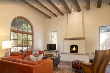 A fireplace inside of a Santa Fe living room with viga-vaulted ceilings