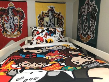 Harry Potter cartoon-themed bedspread and wall posters in vacation bedroom.