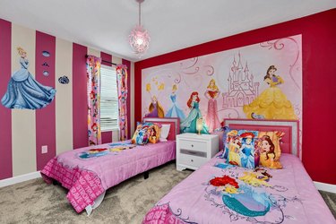Disney Princess-themed bedroom with two bright pink twin beds.