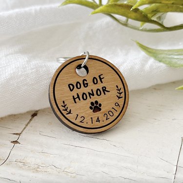 Wood dog tag that reads 'Dog of Honor' and has the date December 14, 2019 etched into it.