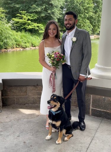 bride and groom pose with dog