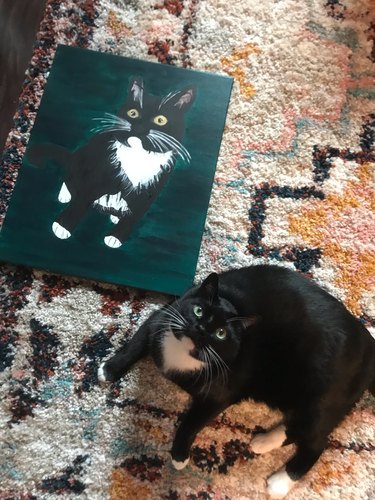 woman paints portrait of cat