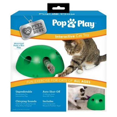 A Pets Know Best Pop N' Play Peek-A-Boo Cat Toy box feauring a gray cat batting at a mouse toy popping our of a hole in the toy