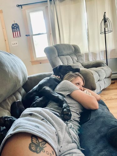 dog spoons woman on couch