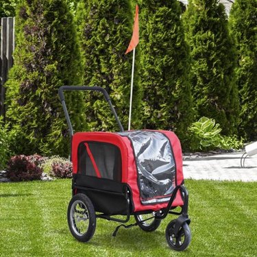 A red and black Aosom Elite-Jr 2-In-1 Dog Pet Bicycle Trailer that converts into a stroller