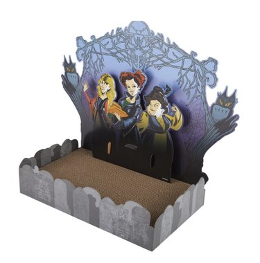 Cat scratcher with a tombstone border and a larger back panel featuring illustrations of the Sanderson sisters in a graveyard with owls looking on.