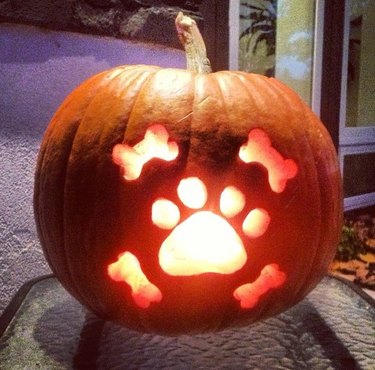 dog's paw print carved into pumpkin