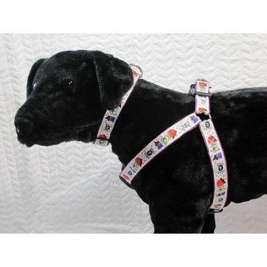 A black stuffed dog wearing a Halloween-themed Boo and Ghosts Design Pet Harness from an Etsy shop