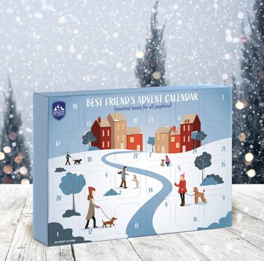 Cardboard advent calendar with pop-out windows depicting a winter village scene of dogs and their owners.