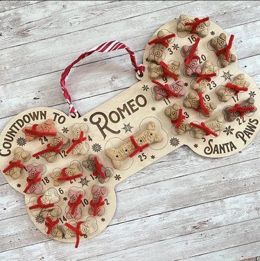 Bone-shaped wooden dog advent calendar with your dog's name in the center and pipecleaners for attaching treats.