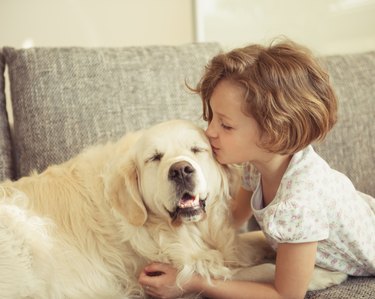 Young girl kissing pet dog