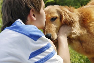 Boy kissing dog