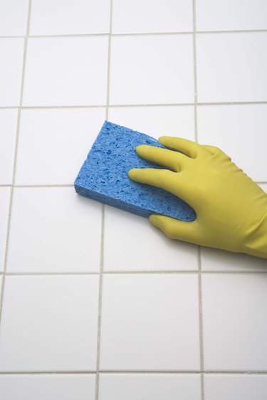 Person using sponge to clean tile