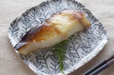 Cooked fish on a plate with chopsticks, overhead view