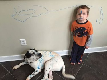 Little boy and dog covered in blue marker.