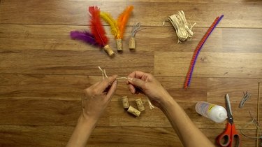 Preparing raffia for DIY cat toys out of wine corks.