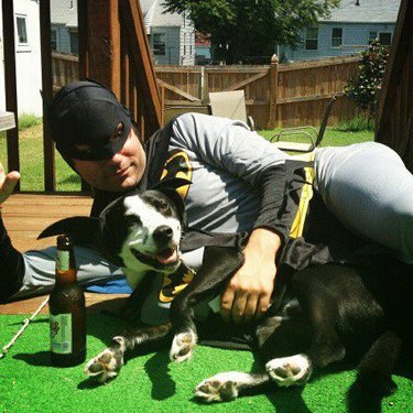 Man and dog in Batman costumes