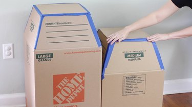 Taping scrap cardboard on top of boxes