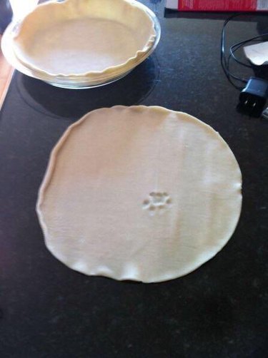 Unbaked pie crust with single cat paw print in the center.