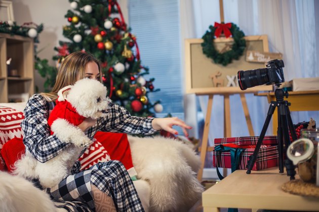Teenage girl filming a video with her dog
